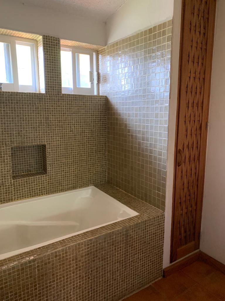 Bathroom with bathtub and tiled shower area